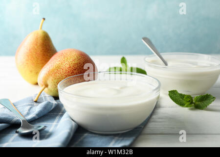 Composizione con crema di yogurt e frutta sul tavolo bianco, spazio per il testo Foto Stock