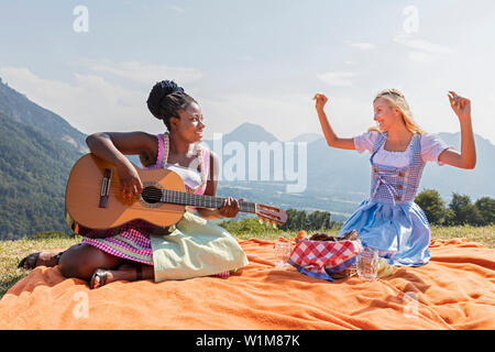 Le ragazze adolescenti godendo con la chitarra durante il picnic, Baviera, Germania Foto Stock