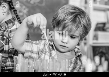 Pupilla in chimica classe. torna a scuola. Il concetto educativo. piccolo scienziato bopy effettuare esperimenti in laboratorio. Scuola laboratorio di chimica. Ragazzo concentrato quasi a studiare a scuola Foto Stock