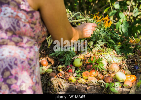 Donna Senior in un giardino con composto ammucchi, Altötting in Baviera, Germania Foto Stock
