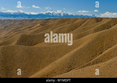 Il paesaggio del deserto con massi montagne coperte di neve di Tien Shan montagne sullo sfondo, Kolsay Lakes National Park, Tien Shan montagne Tian Sh Foto Stock