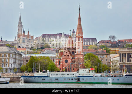 La Chiesa di San Mattia e Chiesa riformata con nave ormeggiata sul fiume Danubio, Budapest, Ungheria Foto Stock