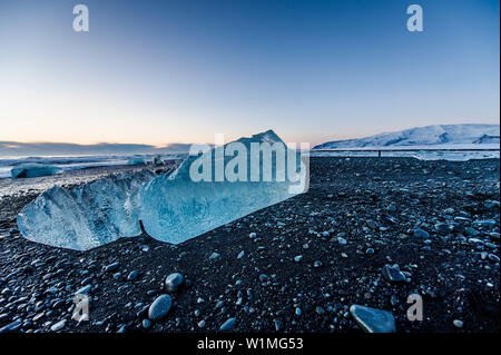 Joekulsarlon, Growler sulla spiaggia al tramonto, Glacierlagoon, ghiacciaio Vatnajoekull, inverno, Islanda Foto Stock