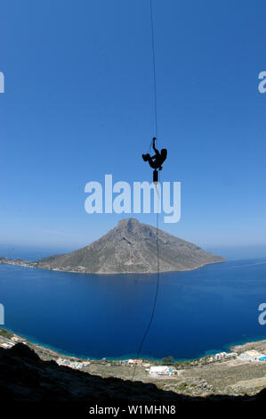 Scalatore scaling up una fune, Kalymnos, Grecia Foto Stock