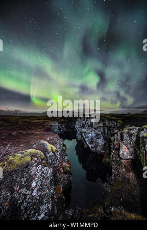 Northern lights aurore boreali sulla tettonica Silfra crack, Parco Nazionale Thingvellir, patrimonio mondiale dell UNESCO, Golden Circle,Sud dell'Islanda, dell'Islanda, Foto Stock