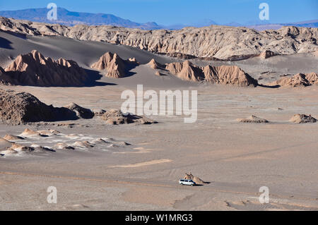 Jeep in pista tra le montagne e le formazioni rocciose, Valle de la Luna e la Valle della Luna, il deserto di Atacama, riserva nazionale Reserva Nacional Los Flam Foto Stock