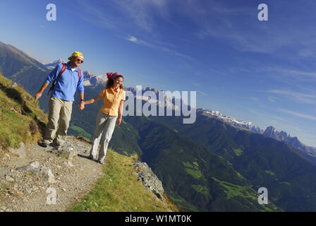 Giovane holding hands camminando lungo il sentiero escursionistico delle Dolomiti in background, Alto Adige, Italia Foto Stock