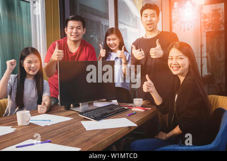 Giovani asiatici freelance lavoro di squadra successo felicità emozione Foto Stock