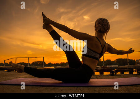 La donna a praticare yoga in sunset. Padangusthasana, Shiva ballando pongono Foto Stock