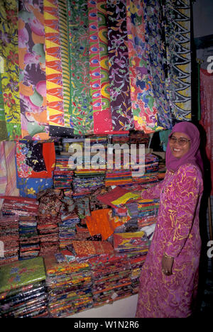 Ridendo donna e panni colorati, Kota Bharu, Batik, East coast, Malaysia, Asia Foto Stock