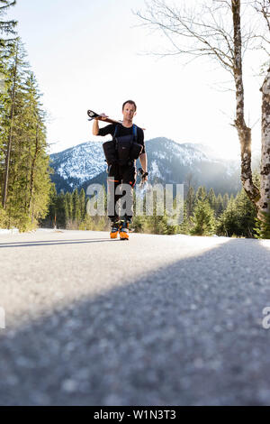 Backcountry rider su una strada, Ammergauer Alpi, Tirolo, Austria Foto Stock