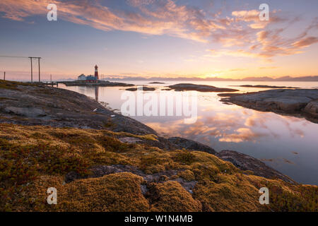 Romantico tramonto sopra il faro Tranøy Fyr sulla costa del fiordo di gilet con la parete Lofoten in background, Tranøya, Hamarøy, Nordland, n. Foto Stock