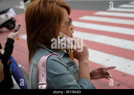 Giovane donna, telefono cellulare, telefono cellulare, attraversamento pedonale, Shibuya, Tokyo, Giappone Foto Stock