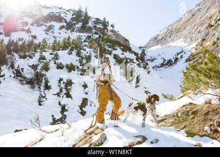 Backcountry rider con il suo cane nella Ammergauer Alpi, Baviera, Germania Foto Stock