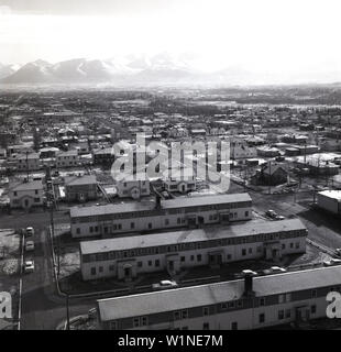 Vista aerea storica degli anni '1950 sugli alloggi e sulla struttura stradale circostante in una parte della città di Anchorage, Alaska, Stati Uniti. Vista in lontananza la catena montuosa di Chugach. Foto Stock