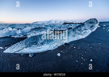 Joekulsarlon, Growler sulla spiaggia al tramonto, Glacierlagoon, ghiacciaio Vatnajoekull, inverno, Islanda Foto Stock