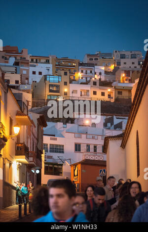 La gente a piedi attraverso le strette viuzze durante una processione al tramonto, capitale San Sebastian de la Gomera, La Gomera, isole Canarie, Spagna Foto Stock