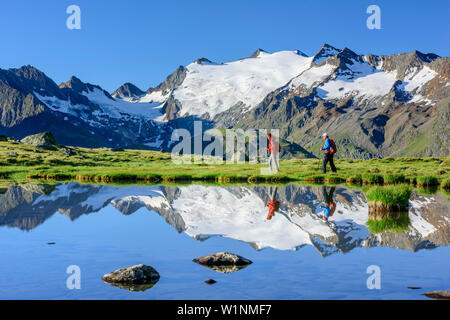 Donna e uomo escursioni al lago di montagna, Alpi Oetztal in background, lago Soomsee, Obergurgl Oetztal, Alpi, Tirolo, Austria Foto Stock