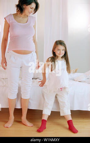 Bambina imitando la madre in stato di gravidanza Foto Stock