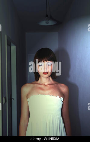 Rouged giovane donna che indossa un abito Foto Stock