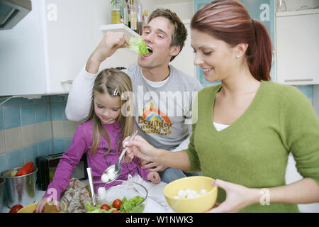 Giovane famiglia preparare una insalata in una cucina domestica, Monaco di Baviera, Germania Foto Stock