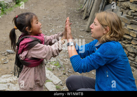 Giovane donna giocando con una piccola ragazza in Nar su Nar Phu Trek, Nepal, Himalaya, Asia Foto Stock