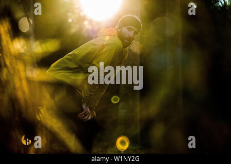 Giovani runner maschio avente una breve pausa in una foresta, Allgaeu, Baviera, Germania Foto Stock