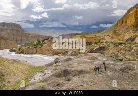 Quattro gli escursionisti, trekking vicino a Tangge, tibetian villaggio con un Gompa buddista nel Kali Gandaki valley, la più profonda valle nel mondo, fertile fie Foto Stock