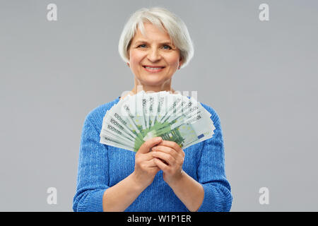 Senior donna con centinaia di euro banconote denaro Foto Stock