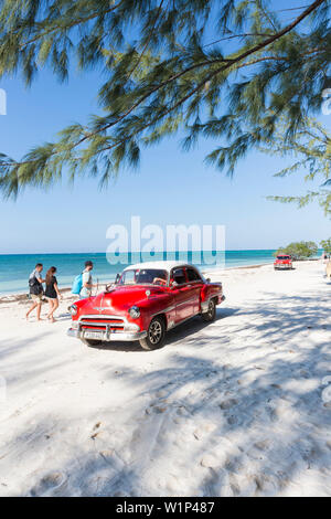 Oldtimer rosso sulla spiaggia di Cayo Jutias, vacanza in spiaggia, solitaria spiaggia da sogno, piccola e bella spiaggia di sabbia, mare blu turchese, Palm tree, viaggi in famiglia Foto Stock