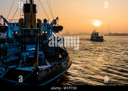 Sunrise su una giornata invernale e nel porto di Amburgo al museo porto Oevelgoenne con il traghetto sul fiume Elba, Amburgo, Germania Foto Stock