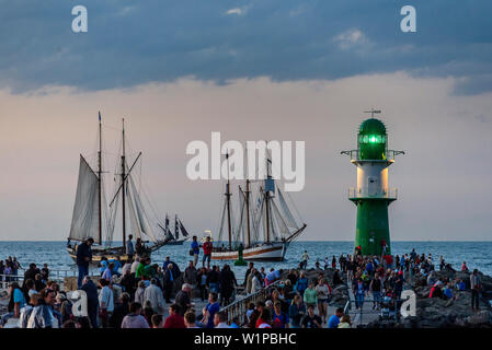 Barche a vela a Warnemünde con curiosi e il faro per la Hanse Sail, Warnemünde, Rostock, Mar Baltico, Meclenburgo-Pomerania Occidentale, Germania Foto Stock