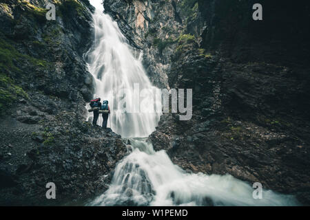 Escursionista di fronte alla cascata Simms, E5, Alpenüberquerung, seconda fase, Lechtal, Kemptner Hütte a Memminger Hütte, Tirolo, Austria, Alpi Foto Stock