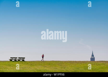 Jogging sulla diga verso Westturm, Wangerooge, Ostfriesland, Bassa Sassonia, Germania Foto Stock