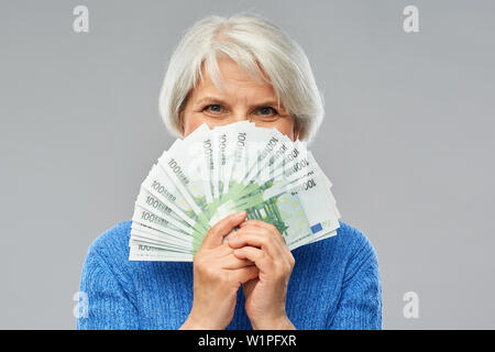 Senior donna con centinaia di euro banconote denaro Foto Stock