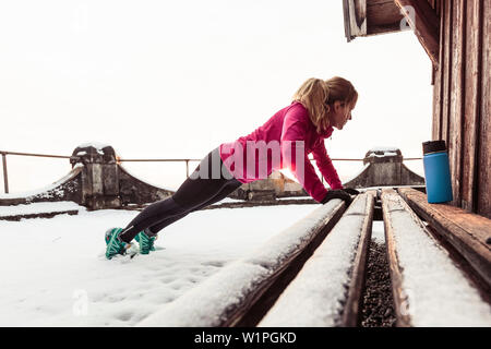 Giovane donna stretching vicino al lago di Starnberg, Baviera, Germania. Foto Stock