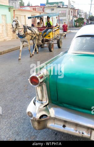 Oldtimer e carrozza trainata da cavalli su un vuoto street, città coloniale, famiglia viaggi a Cuba, congedo parentale, vacanze, time-out, avventura, Cienfuegos, Foto Stock