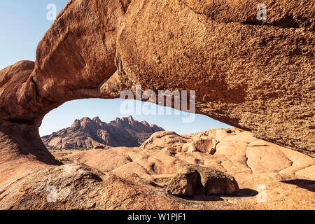 Pontok montagne, visto attraverso un arco di roccia, Spitzkoppe, Erongo, Namibia. Foto Stock