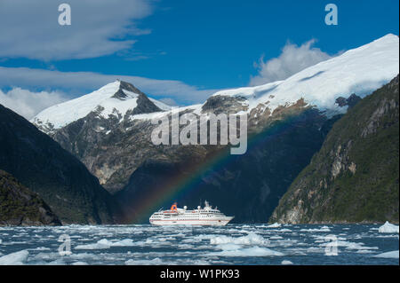 Un arcobaleno moduli sopra Expedition nave da crociera MS Hanseatic (Hapag-Lloyd Crociere), Ghiacciaio Garibaldi, in prossimità del Canale di Beagle, Alberto De Agostini National Par Foto Stock