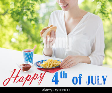 Close up della donna mangiare hotdog e patatine fritte Foto Stock