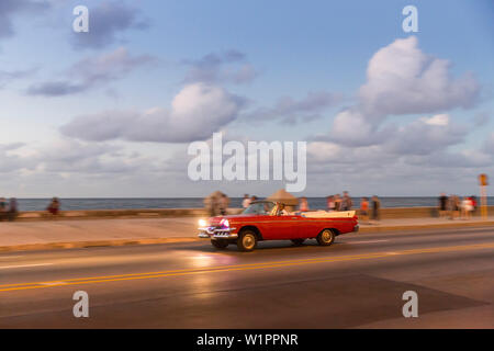 Red oldtimer, cabriolet, turisti, guidando lungo il Malecon, taxi, centro storico, centro città vecchia Habana Vieja, Centro Habana, famiglia viaggi a Cuba, h Foto Stock