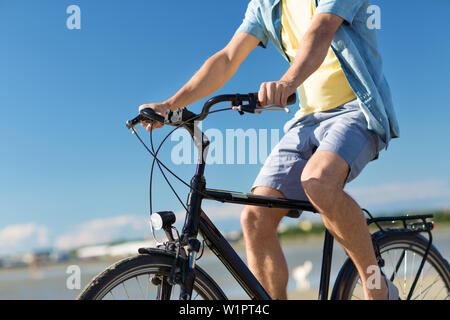 Close up uomo bicicletta equitazione lungo la spiaggia di estate Foto Stock