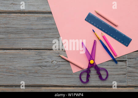 Hobby creativi forniture d'arte su carta di colore rosa. Overhead composizione scrivania Foto Stock