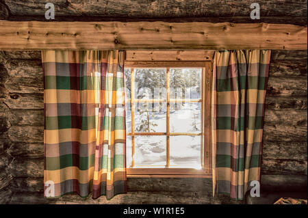 Visualizza la finestra di un accogliente log cabin sul snowscape, Luosto, Lappland finlandese Foto Stock