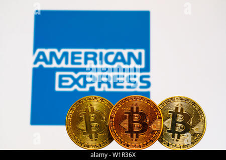 Oro Bitcoin monete con la American Express logo su sfondo dello schermo. Un nuovo tipo di business finance concetto. Foto Stock