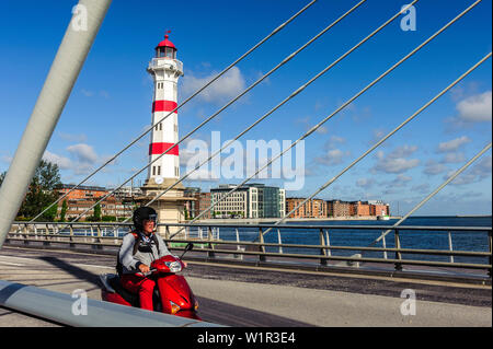 Rosso Bianco faro in sarnated area portuale, rosso scooter in primo piano su un ponte, Malmo Svezia meridionale, Svezia Foto Stock