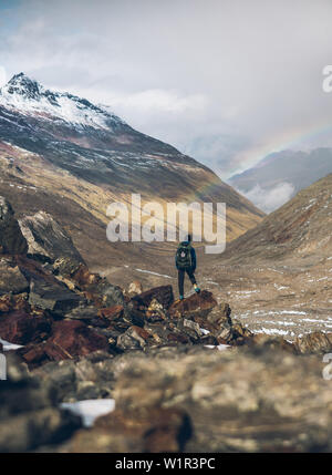 Scalatore gode di vista di arcobaleno e panorama di montagna, E5, Alpenüberquerung, 6a tappa, sfiato,Niederjochbach, rifugio Similaun, Val Senales, Vernago reservoi Foto Stock