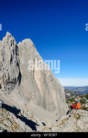 L uomo e la donna seduta al Ellmauer Tor e guardando verso Christaturm e Fleischbank, Ellmauer Tor, Wilder Kaiser, Kaiser gamma, Tirolo, Austria Foto Stock