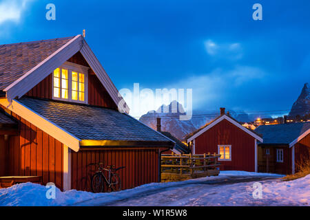 In legno rosso rorbu capanne nel villaggio di pescatori di Reine, Moskensoya, Isole Lofoten in Norvegia, Skandinavia, Europa Foto Stock