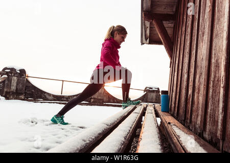 Giovane donna stretching vicino al lago di Starnberg, Baviera, Germania. Foto Stock